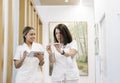 Two nurses walk together looking at a tablet in the hallway Royalty Free Stock Photo