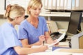 Two Nurses Working At Nurses Station