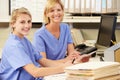 Two Nurses Working At Nurses Station