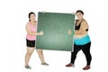 Two obese women with chalkboard on studio