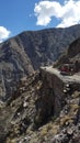 Two off-road cars encounter on narrow rocky road with steep valley