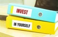 Two office folders with text INVEST IN YOURSELF Royalty Free Stock Photo