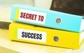 Two office folders with text SECRET TO SUCCESS