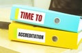 Two office folders with text TIME TO ACCREDITATION