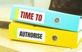 Two office folders with text TIME TO AUTHORISE