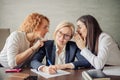 Two office gossips whispering into boss ears from both side, telling her rumors