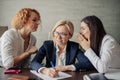 Two office gossips whispering into boss ears from both side, telling her rumors