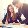 Two office workers discussing about papers at desk Royalty Free Stock Photo