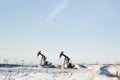 Two oil pump jacks in winter Royalty Free Stock Photo