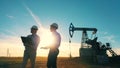 Two oilmen examining an oilfield