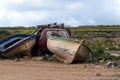 Two old abandoned fishing boats and a red wrecked car in a garbage dump. Abandoned things. Transport Royalty Free Stock Photo