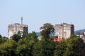 Two old apartment buildings with dilapidated facade above other buildings and family houses surrounded with dense trees Royalty Free Stock Photo