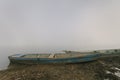Two old blue weathered shabby retro boats on the riverbank in thick fog. Copy space.