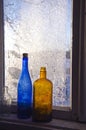 Two old bottle on frosty farm winter window Royalty Free Stock Photo