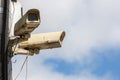 two old CCTV surveillance cameras on street pole at summer day Royalty Free Stock Photo