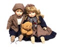 Two old, ceramic dolls and a teddy bear. Old porcelain doll on White Background