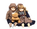 Two old, ceramic dolls and a teddy bear. Old porcelain doll on White Background