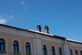 Two old chimneys on the roof of a yellow house against a blue sky Royalty Free Stock Photo