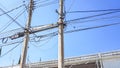 Two old concrete poles with lots of crossed electric cables