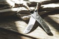 Two old cutlery knives on a wooden rustic table background. Contrasting sunlight from the window and shade. Copy space Royalty Free Stock Photo