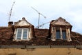 Two old destroyed roof windows with cracked wooden frames on top of ruins of abandoned suburban family house Royalty Free Stock Photo