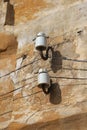 Two old-fashioned out-of-date ceramic insulators mounted on an old damaged wall