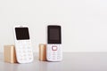 Two old-fashioned white push-button telephones are on the table