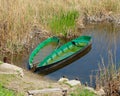 Two old fishing boats thrown on the shore . Worn and faded wooden boats in the yellow grass on the lake shore