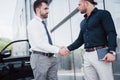 The two old friends of businessmen sign a new agreement in an informal setting, near the office