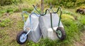 Two old garden carts are parked by a tree