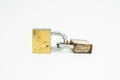 Two old gold-colored padlocks locked and connected to each other laid horizontally Royalty Free Stock Photo