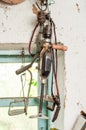 Two old hand drills hang on a garage wall