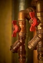 Old water pipes, hot and cold water, with red valves. Vertical orientation. Close up Royalty Free Stock Photo