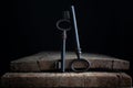 two old keys stand on Old wooden board on a dark background Royalty Free Stock Photo
