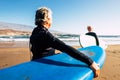 Two old and mature people enjoying their vacations outdoors at the beach having fun together with wetsuits and surfboards ready to Royalty Free Stock Photo