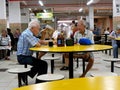 Two old men drink beer and talk quietly in a typical Singapore food court or Hawker Royalty Free Stock Photo