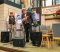 Two old men entertaining the crowd with the ukulele at the 2019 Christmas market in York, UK