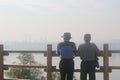 Two old men looking at polluted city sky