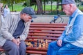 Two old men play chess on a bench in the park. Royalty Free Stock Photo