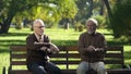 Two old men with walking sticks sitting on bench in park and thinking about life Royalty Free Stock Photo