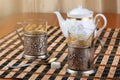 Two old metal cup holder with a bas-relief on the table with porcelain teapot Royalty Free Stock Photo