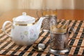 Two old metal cup holder with a bas-relief on the table with white teapot Royalty Free Stock Photo