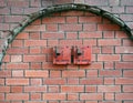 Old red metal fire switches on an exterior brick wall Royalty Free Stock Photo