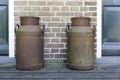 Two old rusted churns