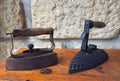 Two old rusty antique iron with wooden handle on old wooden desk Royalty Free Stock Photo