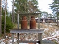 Two old rusty milk jug on a bench