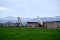 Two old satellite dishes in green field in England Royalty Free Stock Photo