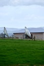 Two old satellite dishes in green field in England Royalty Free Stock Photo