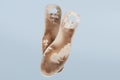Two old, shabby orthopedic insoles isolated on blue background. Dirty leather insoles. Worn out things with holes. Inner