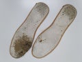 Two old, shabby orthopedic insoles isolated on white background. Dirty leather insoles.